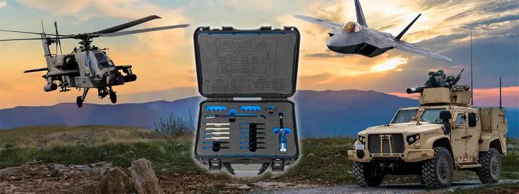 The Quick Skive Removal tool kit surrounded by an Apache helicopter, F-22 fighter jet, and JLTV ground vehicle, with a mountain and sunset in the background